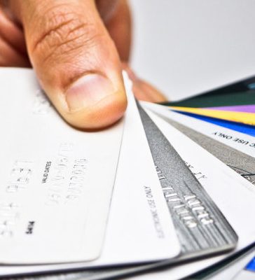 A person holding a collection of credit cards